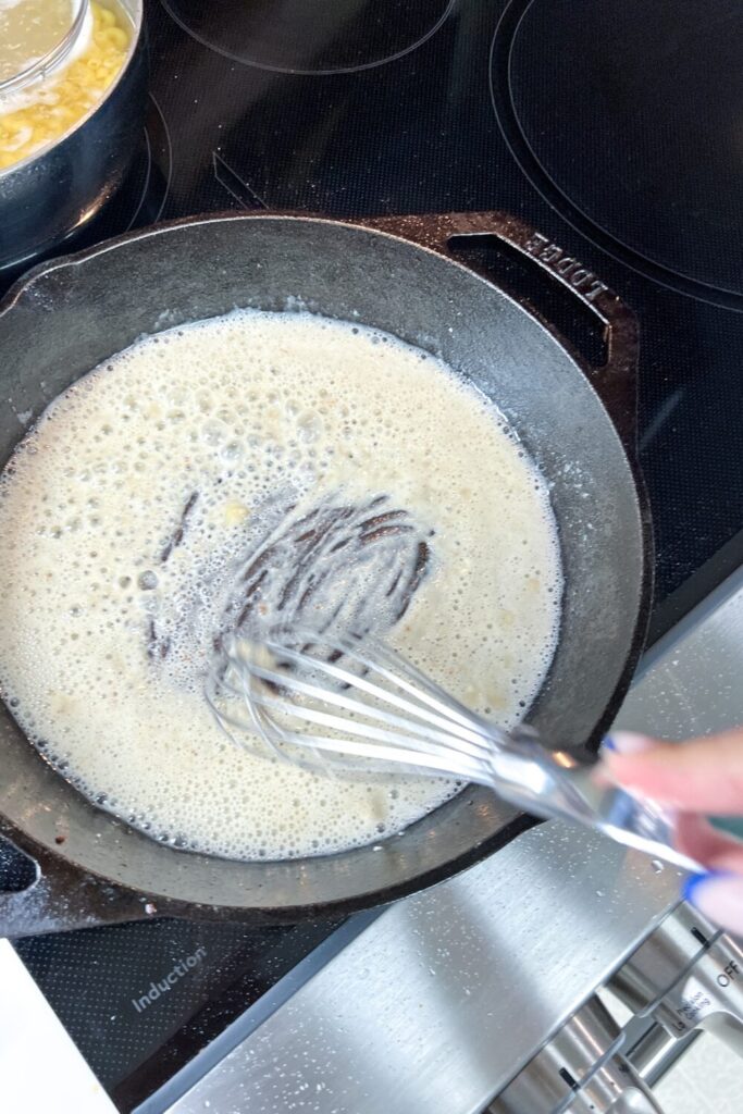 whisking the broth and flour mixture into a paste.