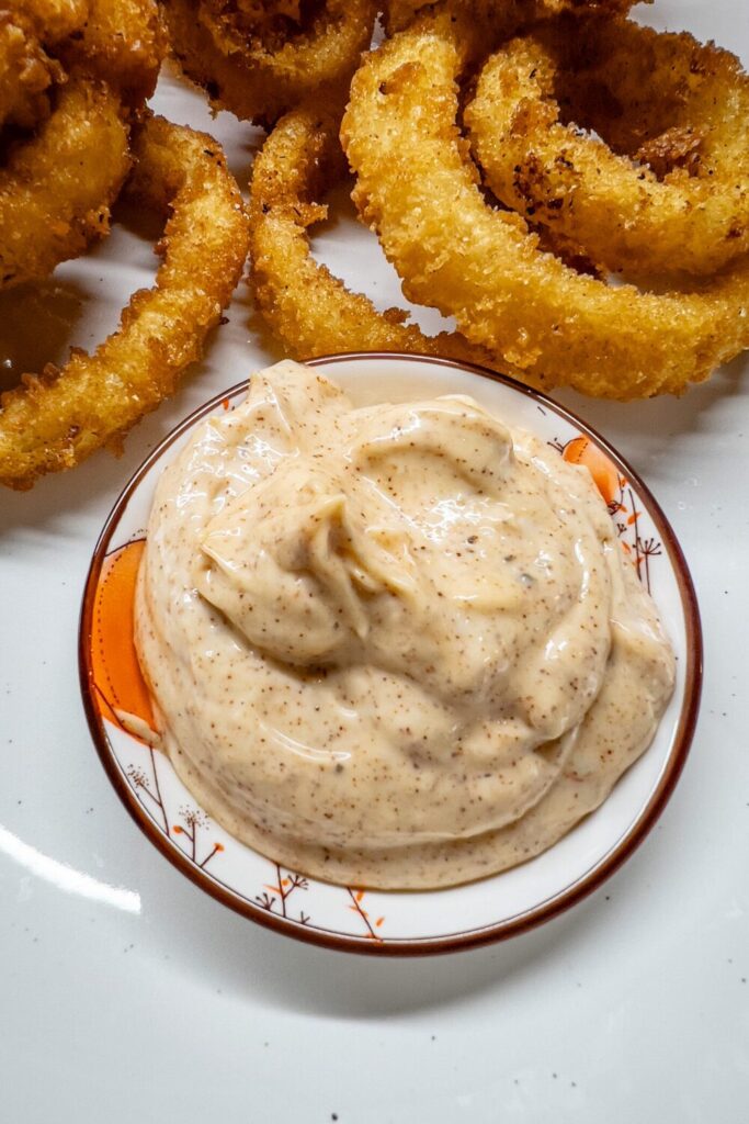 a plate topped with onion rings and Paprika Mayo
