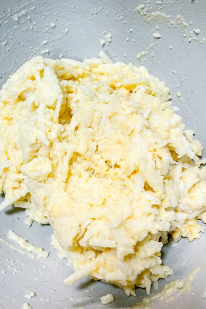 potato pancake batter ready to be cooked, in a mixing bowl on a table