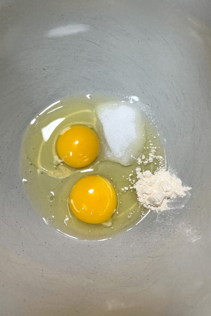 two eggs in a bowl with onion powder, salt and white pepper