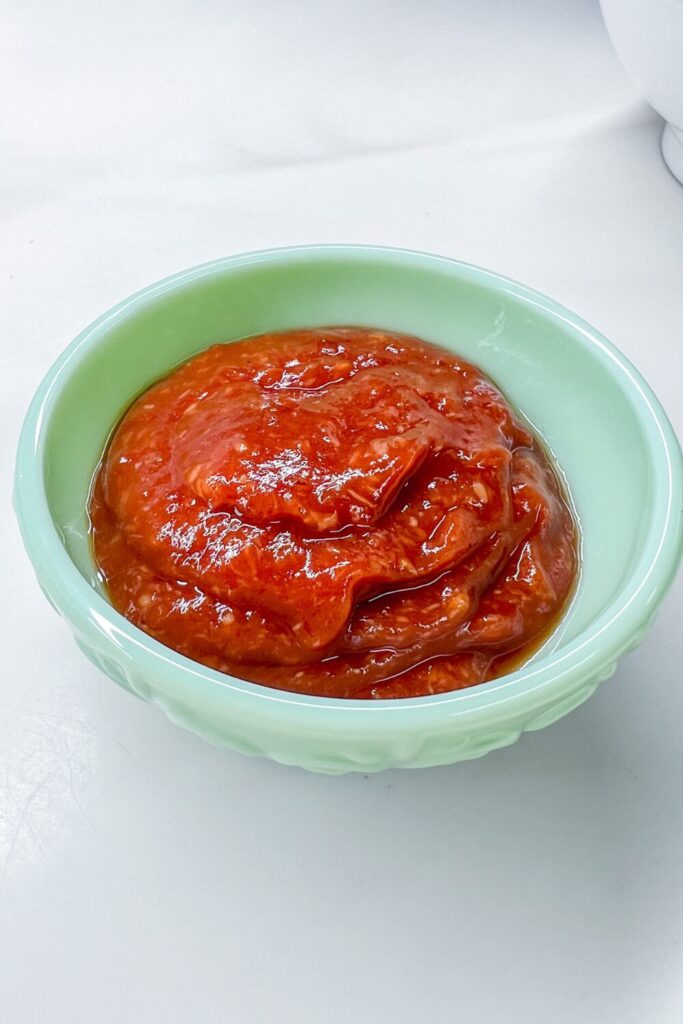 a bowl of cocktail sauce on a white table
