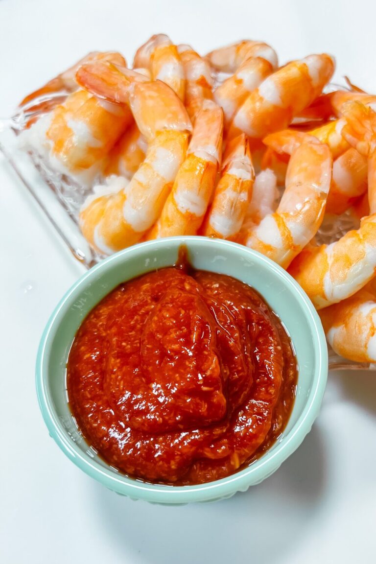 shrimp and sauce on a plate with a bowl of sauce