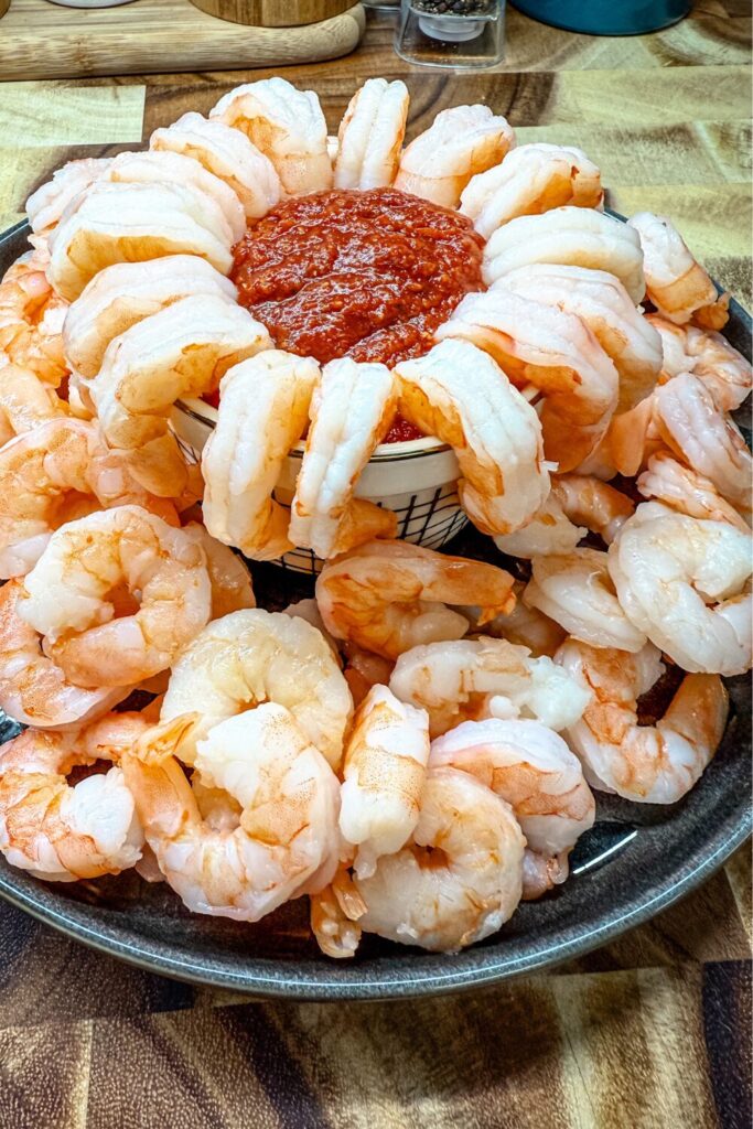 shrimp on a platter with a bowl of sauce