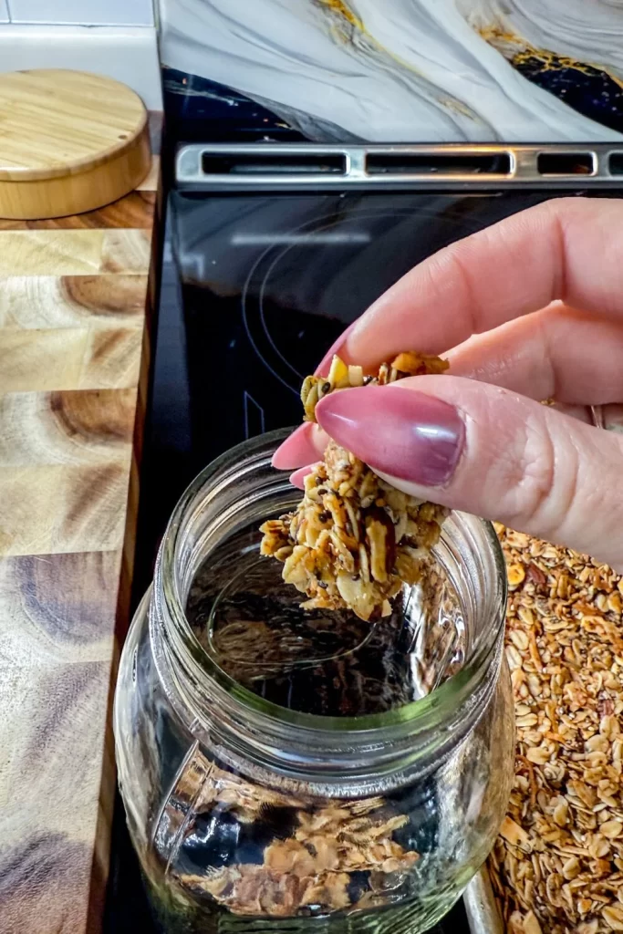 Homemade Granola granola chunk going into jar