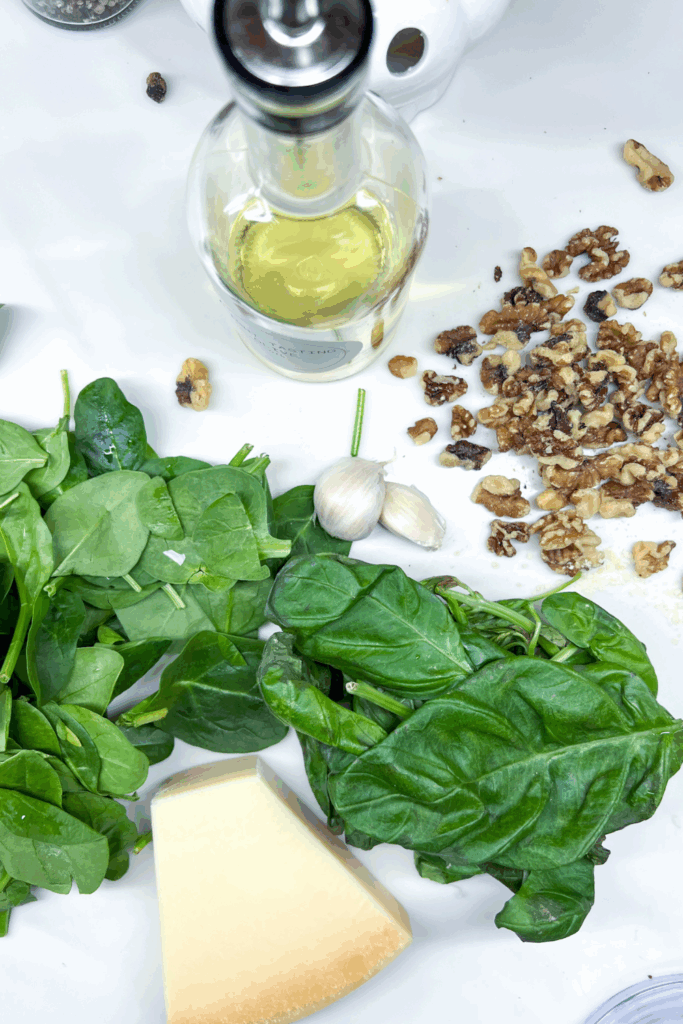 spinach, cheese and walnuts on a white countertop