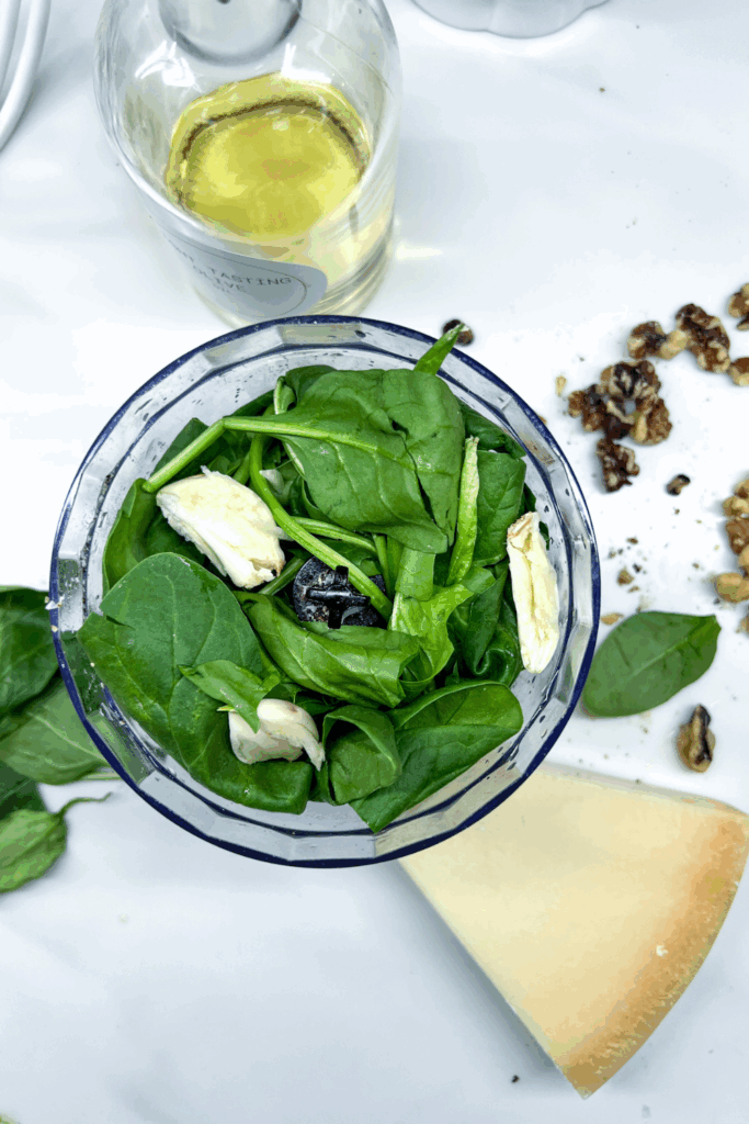 spinach, garlic, walnuts, and Parmesan cheese in a small food processor