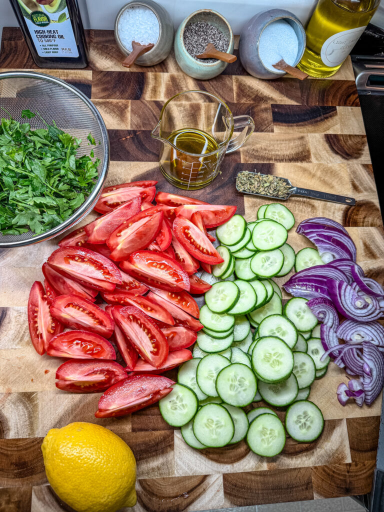 tomatoes, cucumbers and onions cut on a cutting board