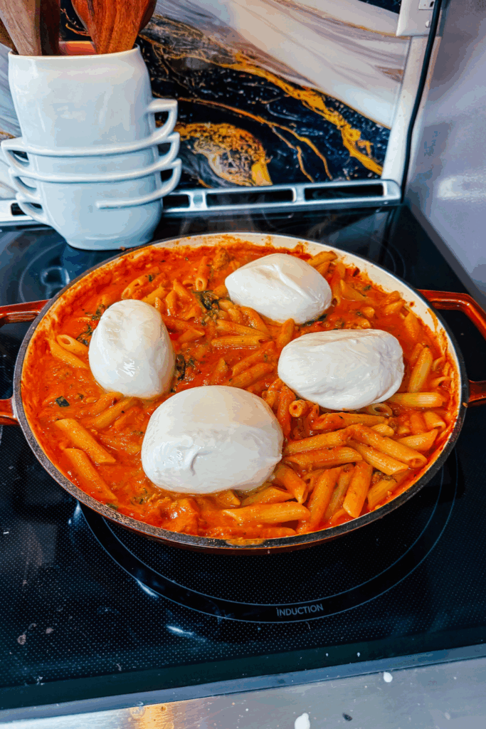adding Burrata on top of finished Creamy Arrabbiata Penne with Sausage