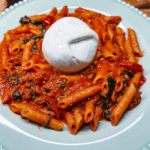 close up of one burratta on top of the Creamy Arrabbiata with Sausage