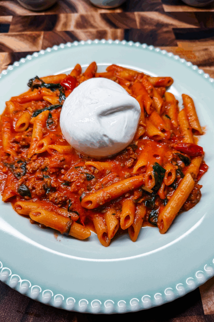 close up of one burratta on top of the Creamy Arrabbiata with Sausage