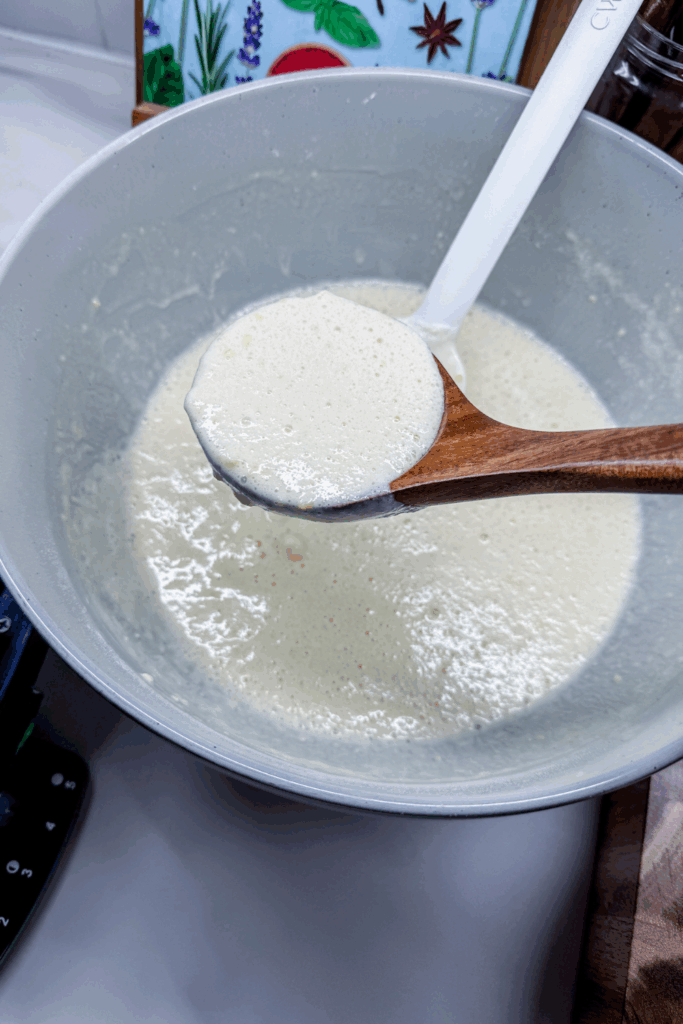a bowl of batter with a wooden ladle