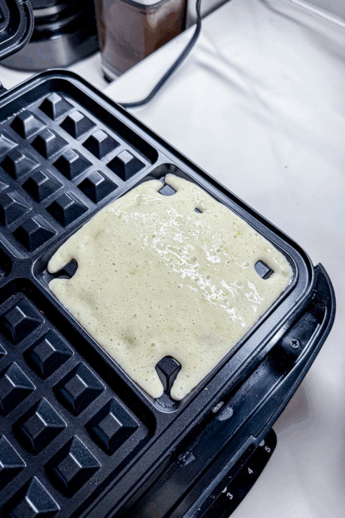 a waffle iron with food in it sitting on top of a counter