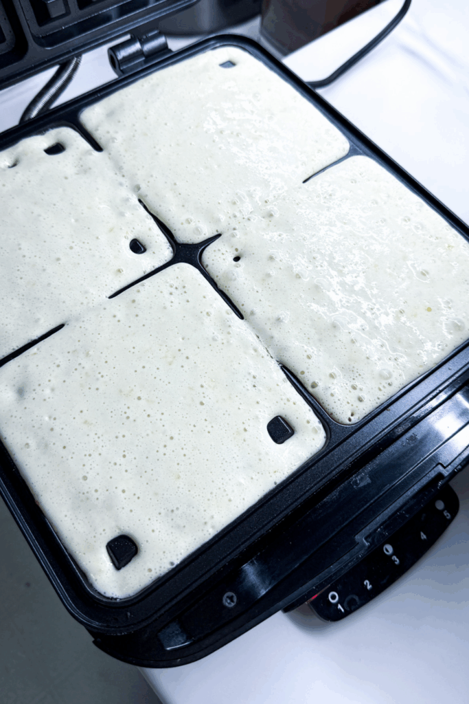 a waffle iron with batter in all four wells