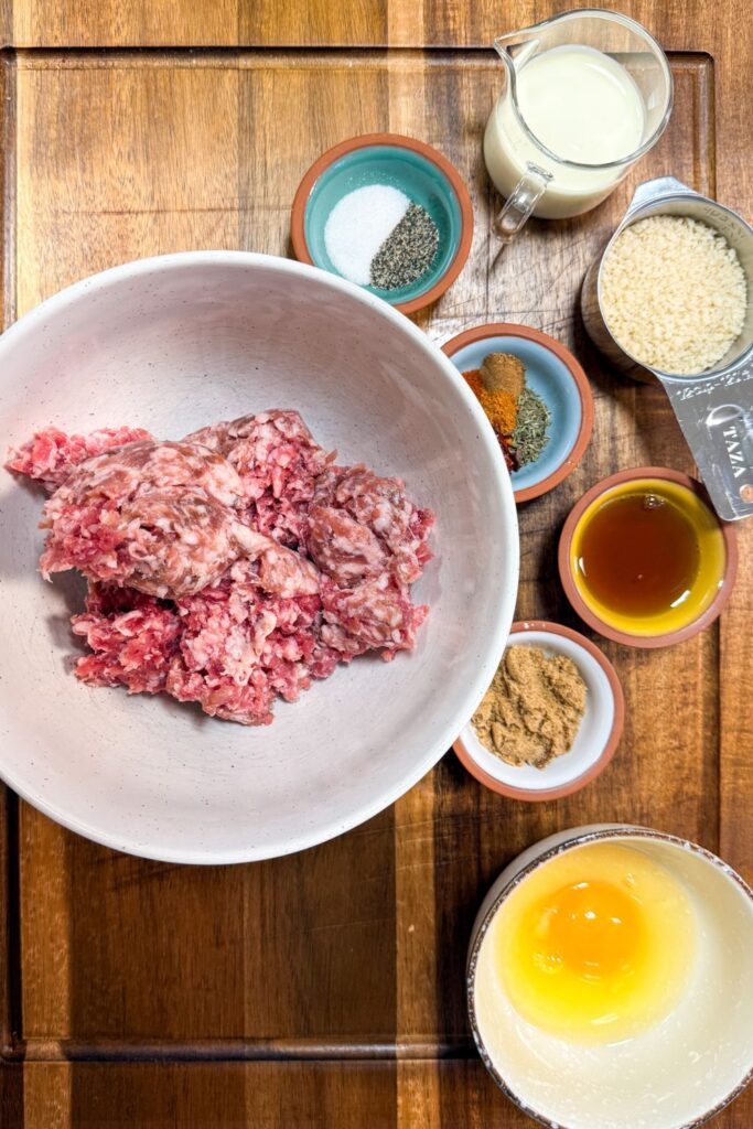 Ingredients for homemade breakfast sausage patties arranged on a cutting board