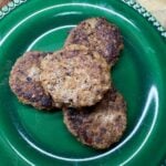 Cooked homemade breakfast sausage patties served on a green plate