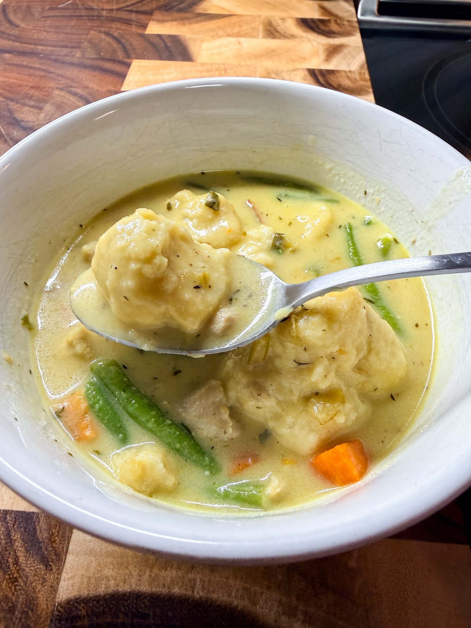 Close up of fluffy dumpling lifted from creamy chicken and dumplings soup