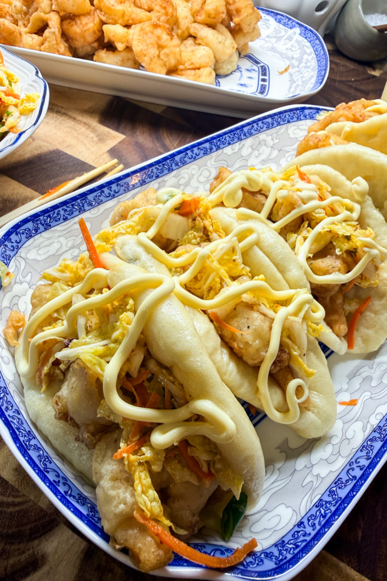 Close up of shrimp bao bun sandwiches topped with sesame coleslaw and Japanese mayo