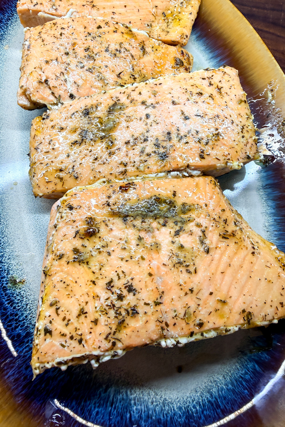 Easy oven-baked salmon served on plate with olive oil and herbs