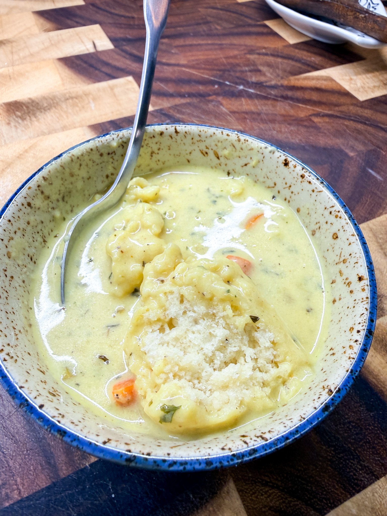 Inside of fluffy homemade dumpling showing soft texture in creamy chicken and dumplings