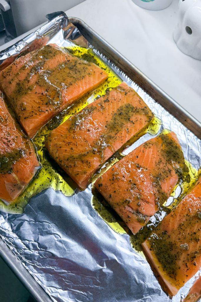 Salmon seasoned with olive oil, herbs, and lemon before baking