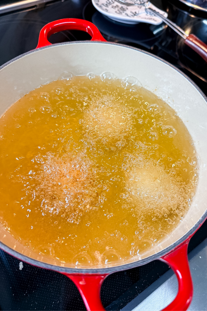 Multiple ham croquettes frying in oil until crispy and golden