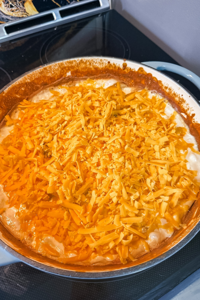 shredded cheddar cheese topping on potatoes au gratin before final bake