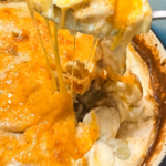 serving cheesy potatoes au gratin with melted cheese stretch