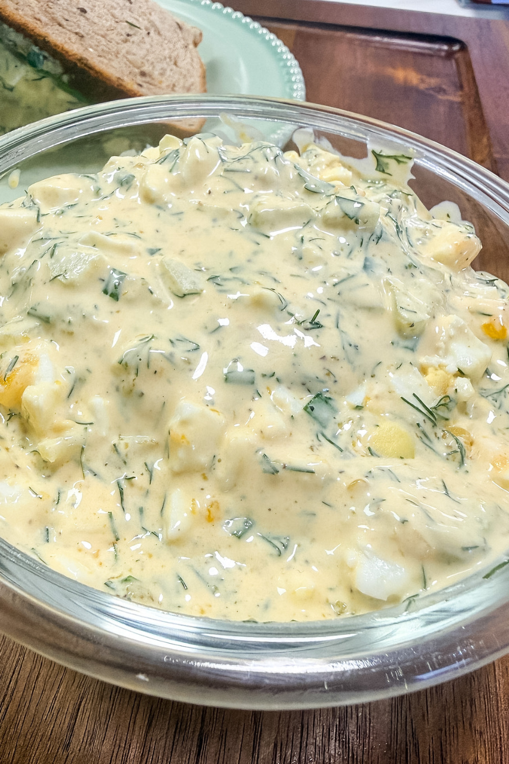 Close up of creamy egg salad with fresh herbs and celery