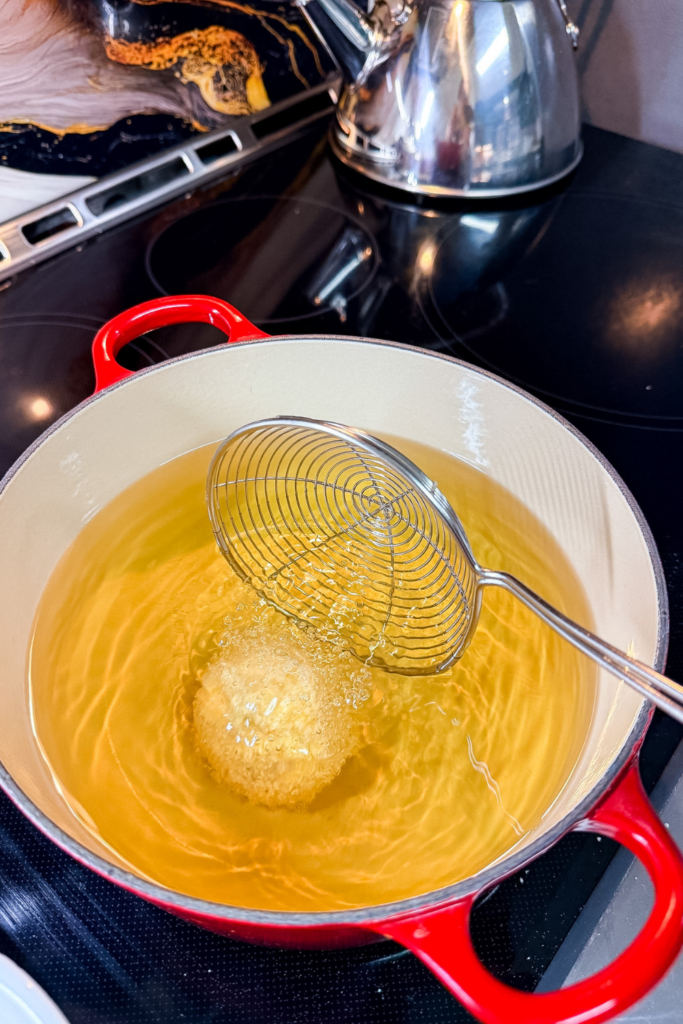 Ham croquette frying in hot oil turning golden brown