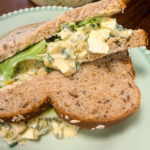 Overhead view of egg salad sandwich with fresh dill and celery