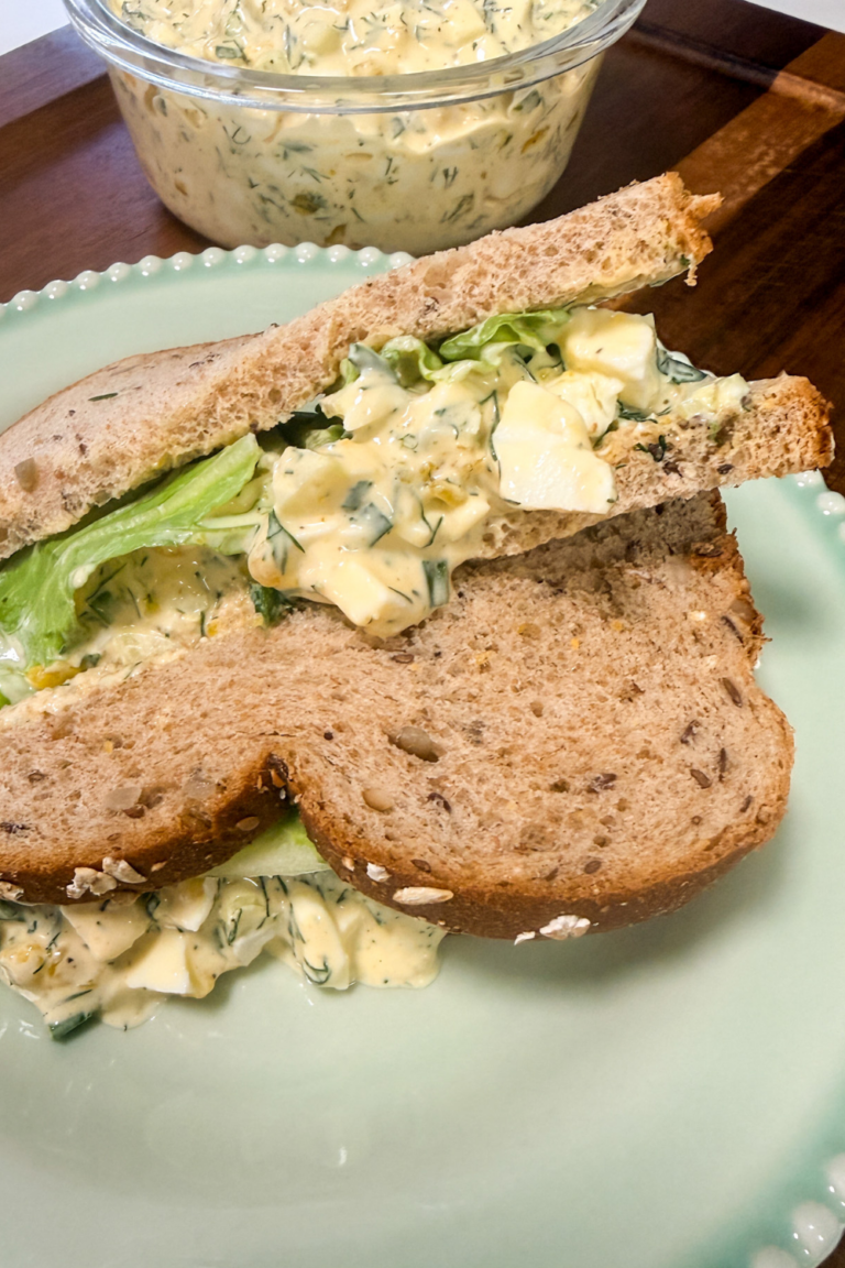 Overhead view of egg salad sandwich with fresh dill and celery