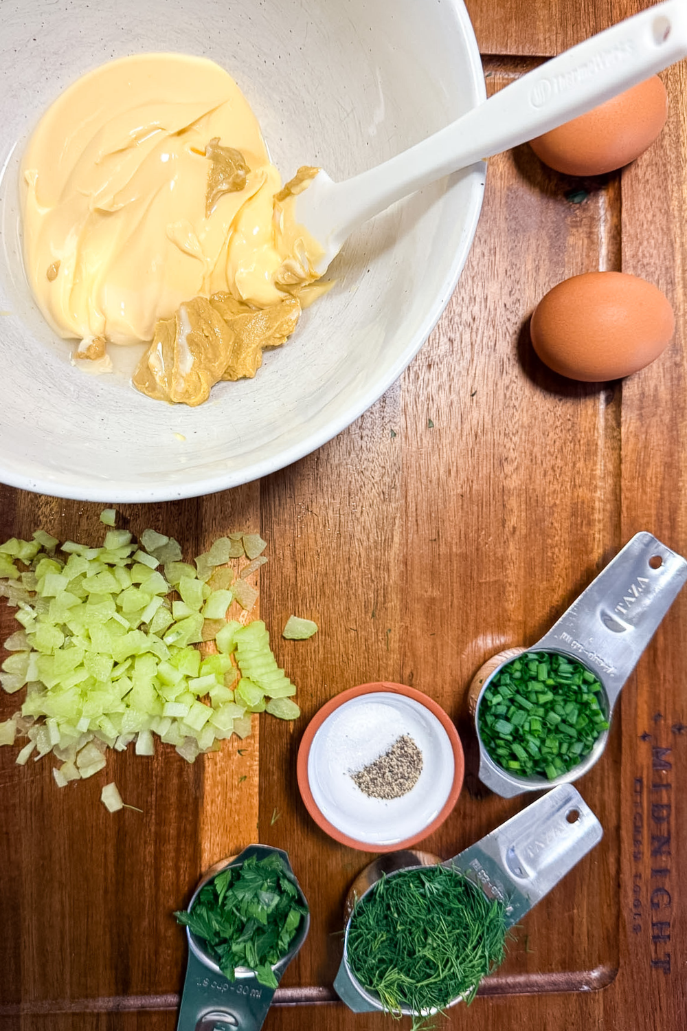 Ingredients for fresh herb egg salad including eggs, Japanese mayonnaise, dill, chives, parsley, celery and mustard