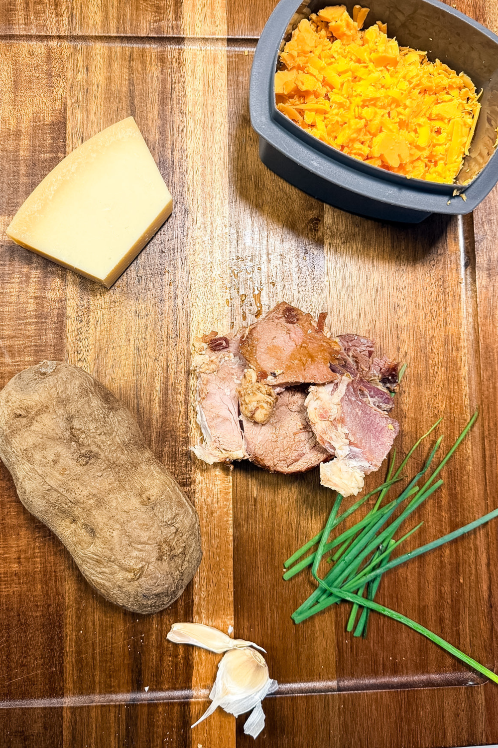 Ingredients for leftover ham croquettes including baked potato, ham, cheese, garlic, and chives