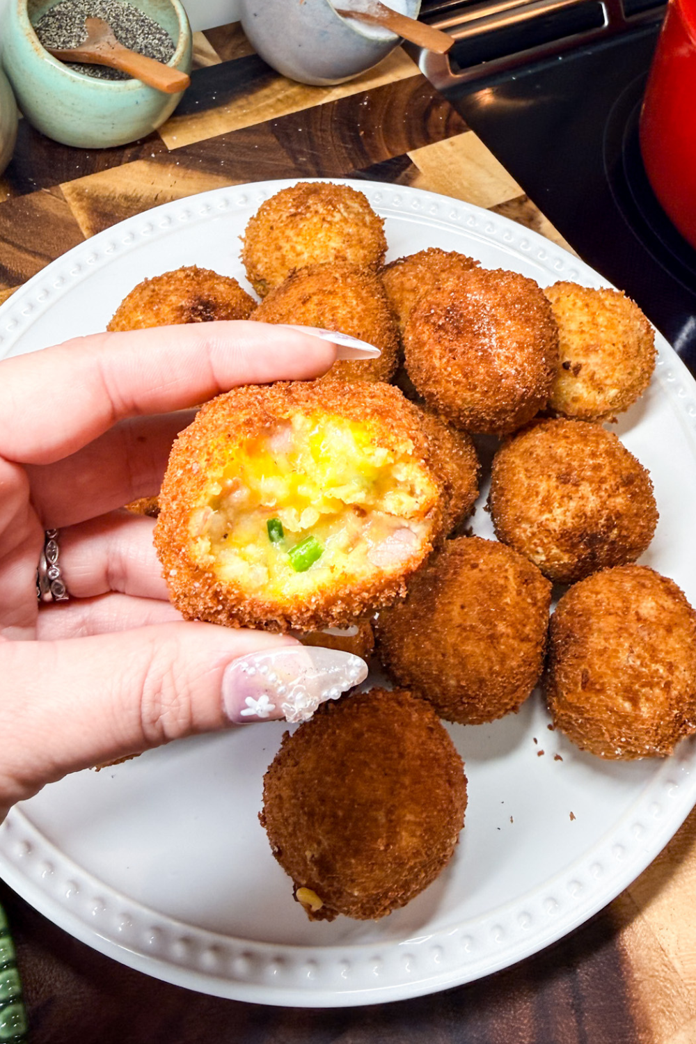 Inside of a ham croquette showing creamy potato, melted cheese, and chopped ham filling