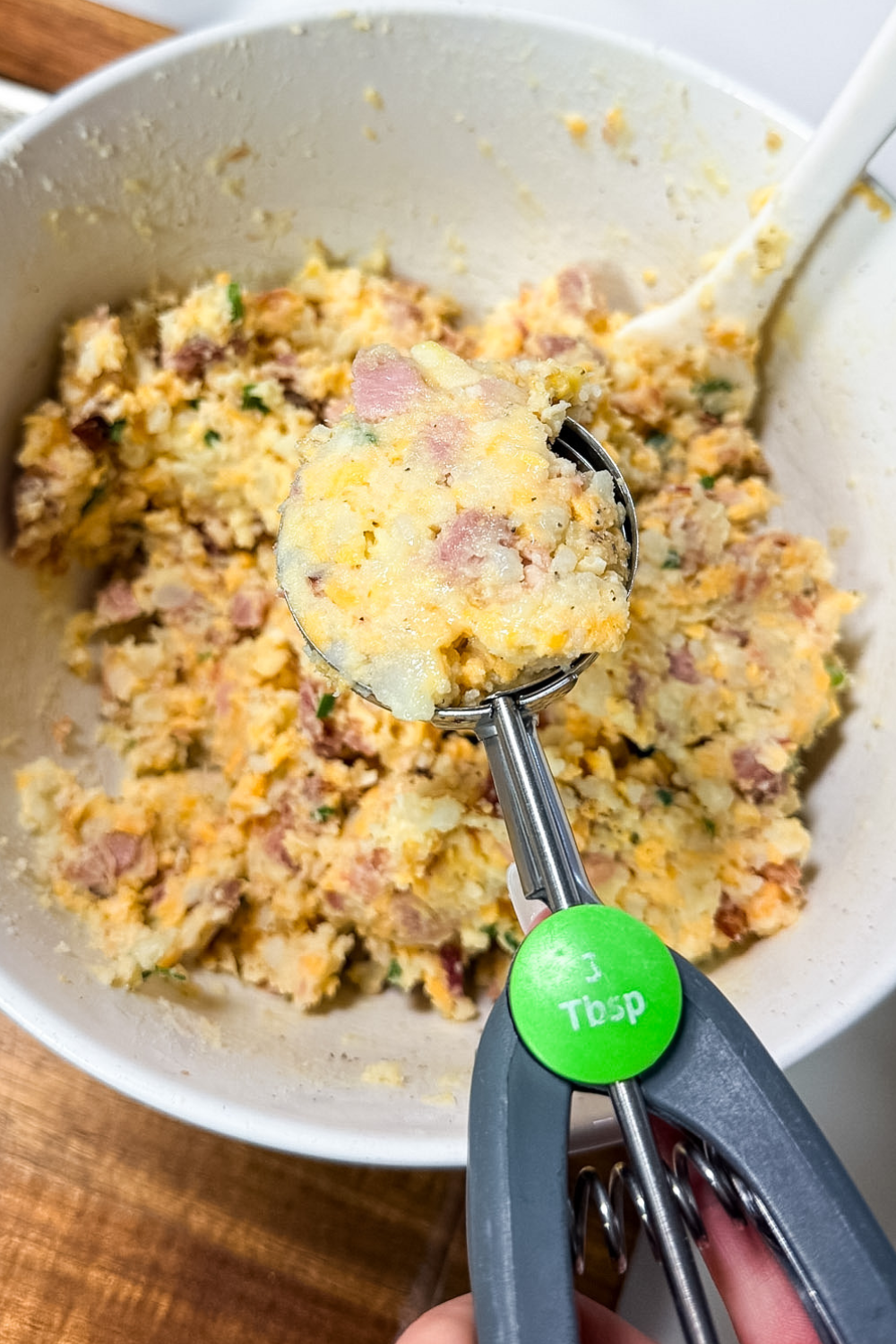 Scooping ham croquette mixture into portions with a cookie scoop