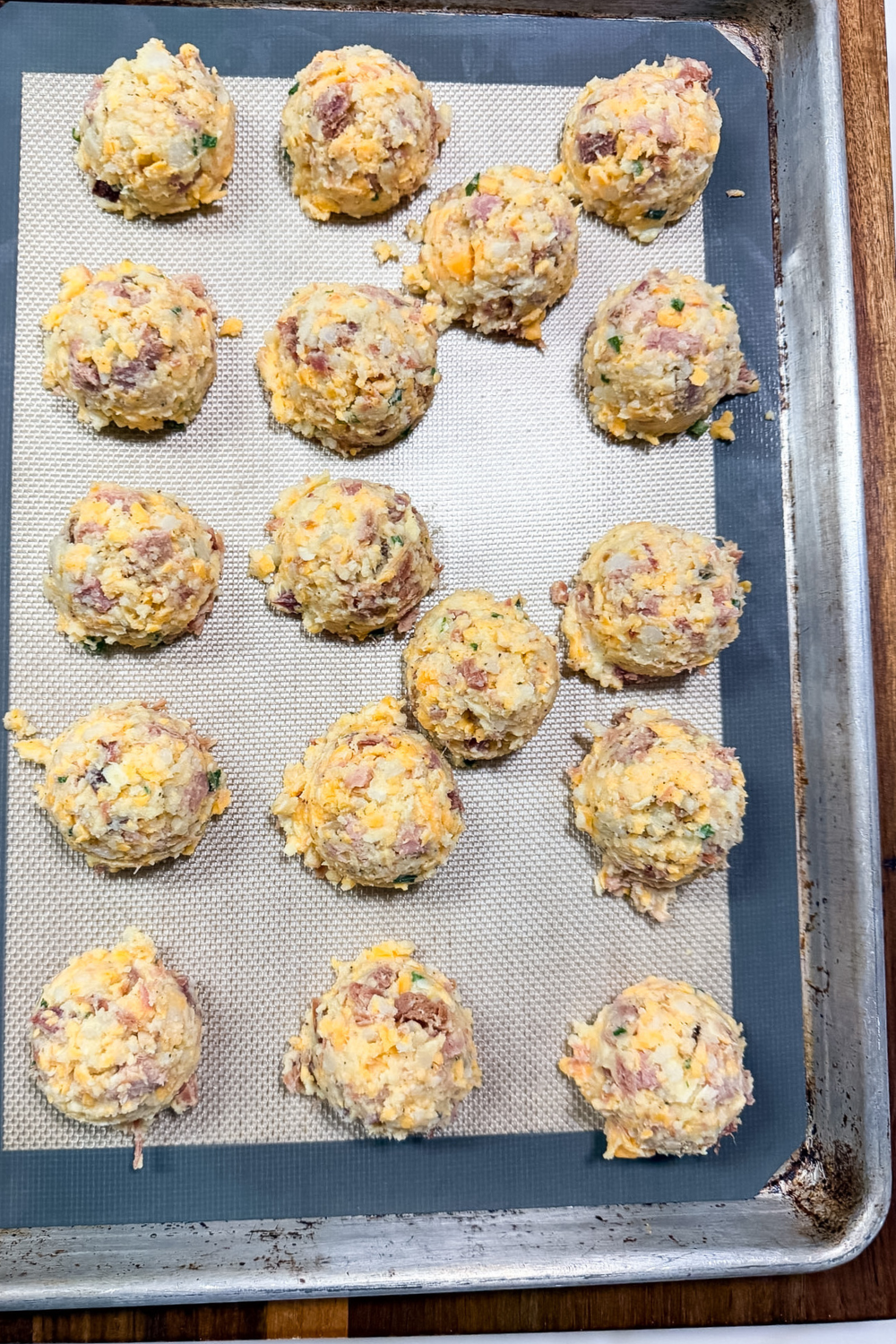 Uncooked ham croquettes shaped on a baking sheet before chilling