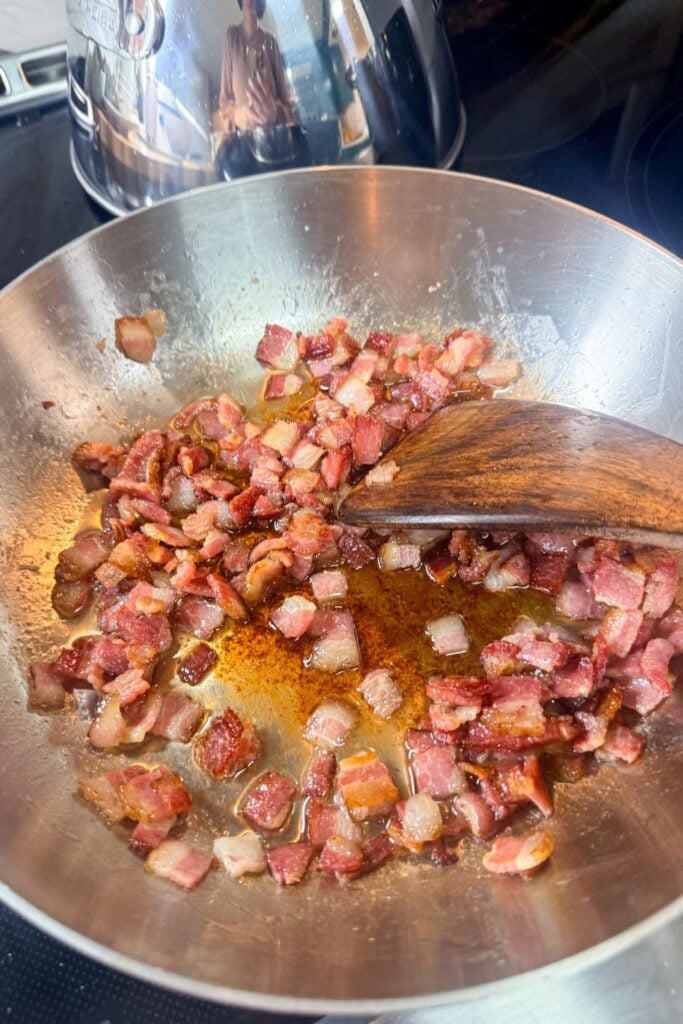 Crispy bacon pieces cooked in skillet for carbonara pasta