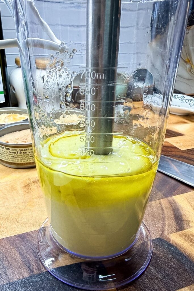 Homemade mayonnaise forming as oil and egg emulsify with immersion blender