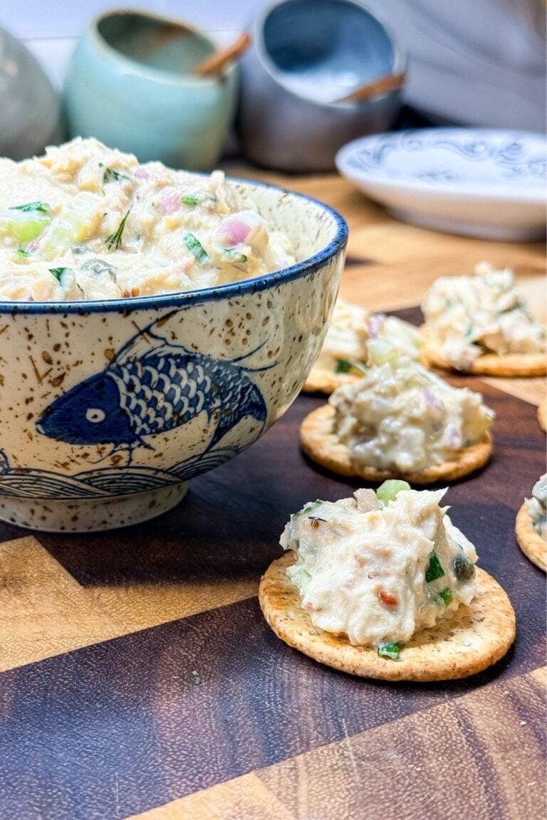 No-waste tuna salad served in a ceramic bowl with crackers on a wooden board