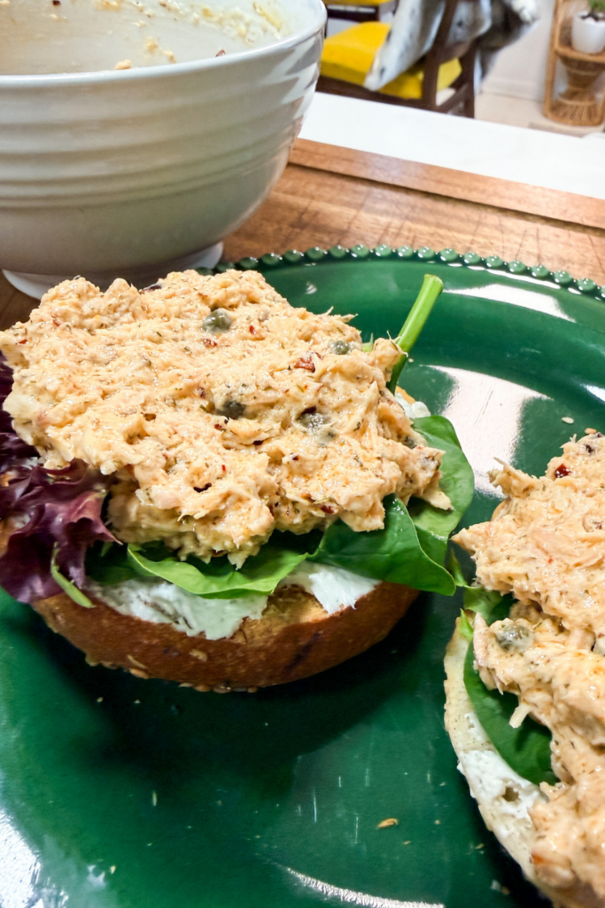 Salmon salad on a toasted bagel with cream cheese and arugula