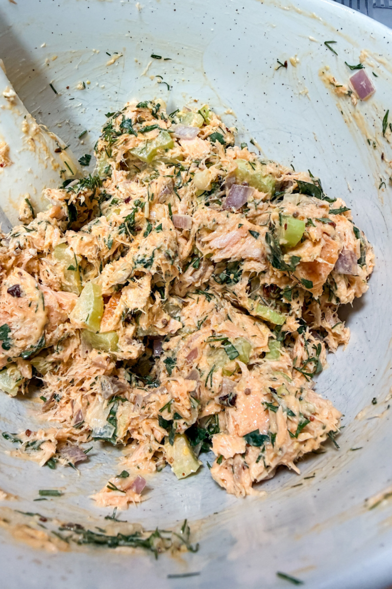 Salmon salad mixed with herbs, celery, and shallots in a bowl