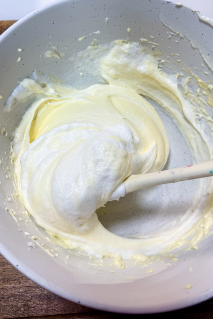 Folding whipped egg whites into mascarpone mixture for a light tiramisu cream