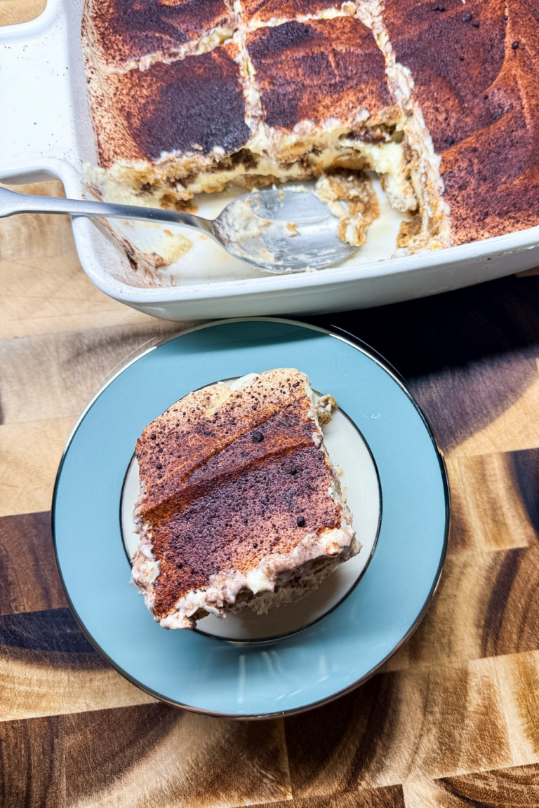 Close-up of a classic tiramisu slice showing layers of espresso-soaked ladyfingers and mascarpone cream