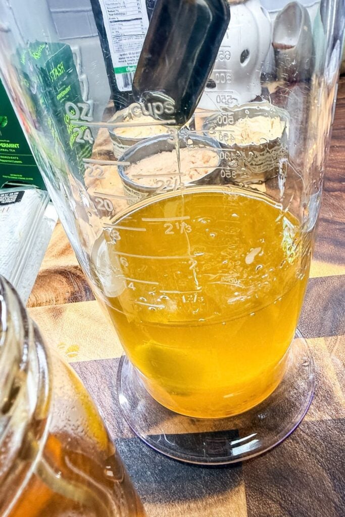 Oil, egg, vinegar, and honey added to a measuring cup before blending into mayonnaise
