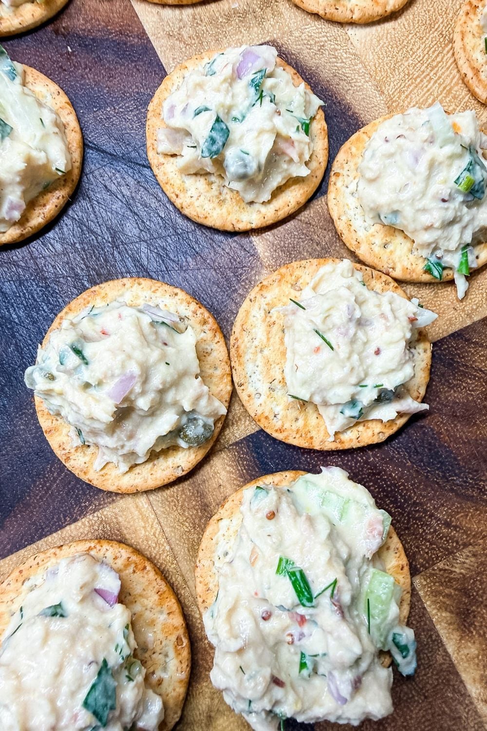 Close-up of tuna salad scooped onto crackers showing texture and ingredients