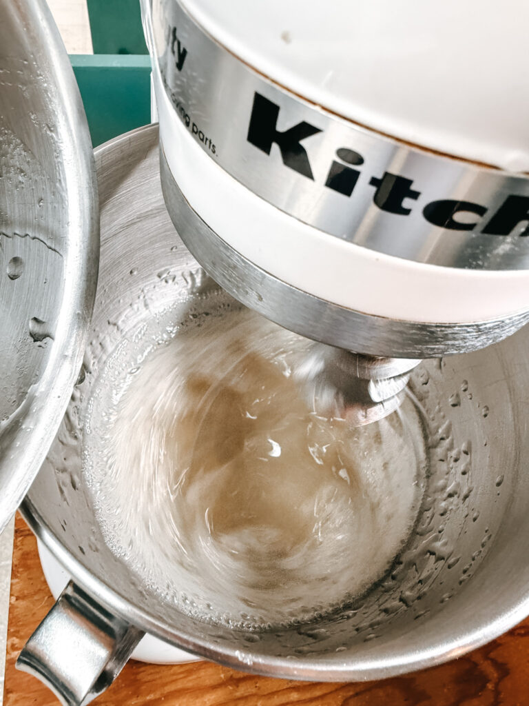 KitchenAid stand mixer running with marshmallow mixture just beginning to come together, thin and glossy