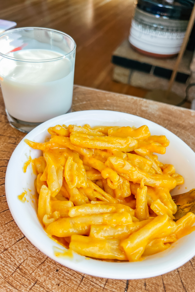 Healthy-ish Stovetop Mac and Cheese on a white plate — glossy golden cheddar sauce coating elbow macaroni